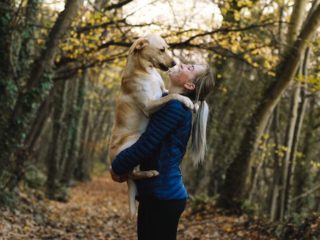woman in wooded glen holding dog